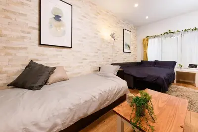 a bedroom with a bed and a couch and a table at Horikiri Kodate - Vacation STAY 8860 in Tokyo