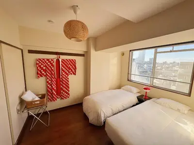 a room with two beds and a flag on the wall at Yuyake in Tokyo