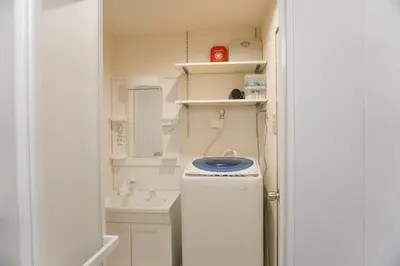 a small bathroom with a washer and a sink at Yuyake in Tokyo