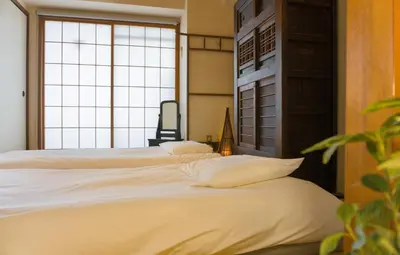 two beds in a room with a large window at Yuyake in Tokyo