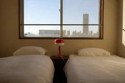 two beds in a room with a window at Yuyake in Tokyo