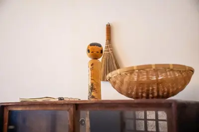 a wooden figurine next to a bowl on a shelf at Nishi-Ikebukuro 3 in Tokyo