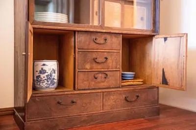 a wooden cabinet with drawers and dishes in it at Nishi-Ikebukuro 3 in Tokyo