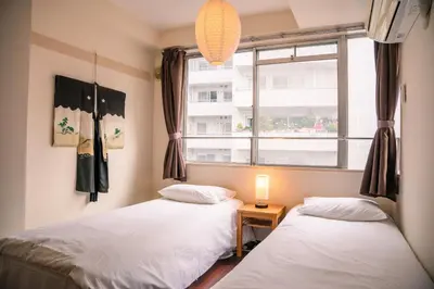 two beds in a room with a window at Nishi-Ikebukuro 3 in Tokyo