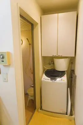a small kitchen with a washing machine and a toilet at Ikebukuro in Tokyo