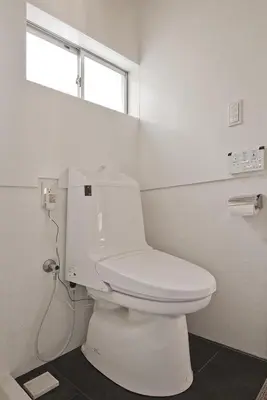a white toilet in a bathroom with a window at Ikebukuro Nigo in Tokyo