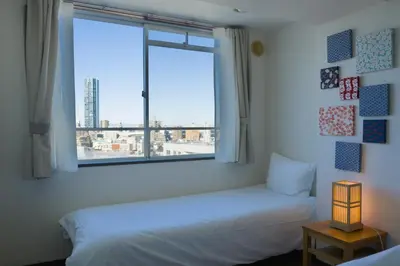a bedroom with a bed and a window with a view at Nishibi in Tokyo