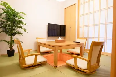 a dining room with a table and chairs and a tv at T-home1 1F in Tokyo