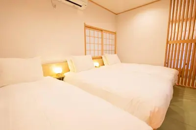 two white beds in a room with a window at T-home1 1F in Tokyo
