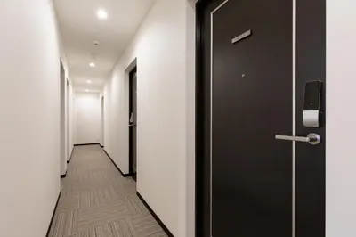 a corridor with a black door at Port House Hatsudai in Tokyo