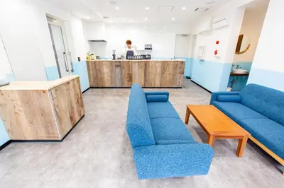 a living room with blue couches and a counter at Port House Hatsudai in Tokyo