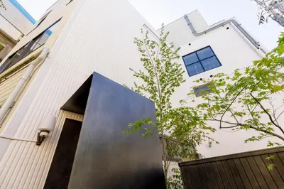 a house with a black door on a white building at tefu yoyogi uehara 101 - good design award - in Tokyo