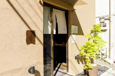 a door to a building with a plant in the doorway at tefu yoyogi uehara 101 - good design award - in Tokyo