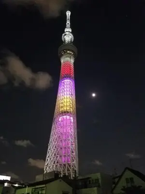 a tall tower lit up in purple and pink at \u30d4\u30e9\u30cd\u30cf\u30a6\u30b9 in Tokyo