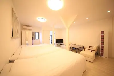 a bedroom with a large white bed and a desk at \u30d4\u30e9\u30cd\u30cf\u30a6\u30b9 in Tokyo