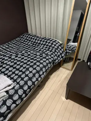 a bedroom with a bed with a black and white comforter at \u6e0b\u8c37\u9053\u7384\u5742307 in Tokyo