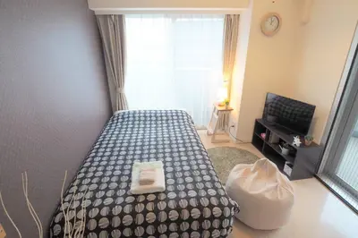 a bedroom with a bed and a large window at \u6e0b\u8c37\u9053\u7384\u5742401 in Tokyo