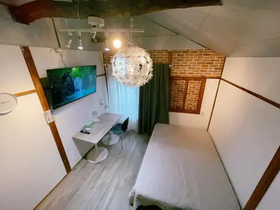an attic room with a table and a chandelier at 2 type room, Akira&chacha guest home杉並区世田谷direct to shinjuku for 13 min 上北沢3分 近涉谷新宿Suitable for three or more people in Tokyo