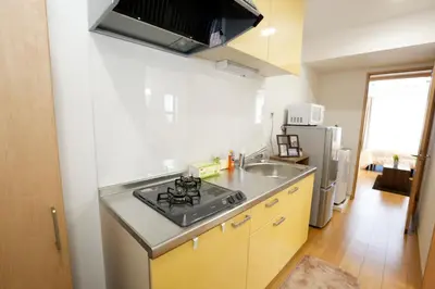 a small kitchen with a sink and a stove at Tokyo Enjoy Hotel in Tokyo