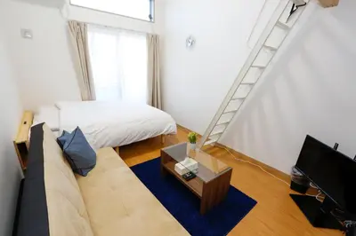 a living room with a couch and a ladder at Tokyo Enjoy Hotel in Tokyo