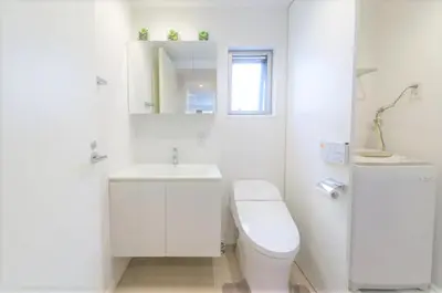 a white bathroom with a toilet and a sink at Salon Shibuya - Vacation STAY 78188 in Tokyo