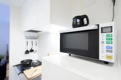 a microwave sitting on top of a white refrigerator at Salon Shibuya - Vacation STAY 78186 in Tokyo