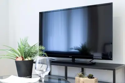 a flat screen tv sitting on a table with a wine glass at Salon Shibuya - Vacation STAY 78186 in Tokyo