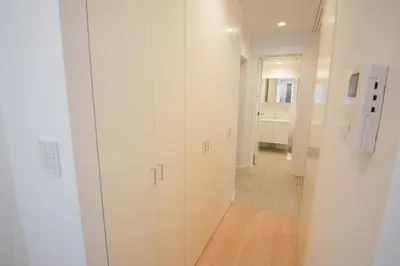 a hallway with white cabinets and a hallway with a bathroom at Salon Shibuya - Vacation STAY 78187 in Tokyo