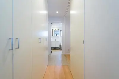 a hallway with white doors and a wooden floor at Salon Shibuya - Vacation STAY 78187 in Tokyo