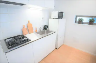 a white kitchen with a sink and a refrigerator at Salon Shibuya - Vacation STAY 78187 in Tokyo