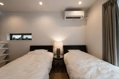 two beds in a room with a lamp on a table at Salon Shibuya - Vacation STAY 78187 in Tokyo