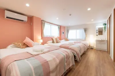 a row of beds in a room with orange walls at TK Court Ojima - Vacation STAY 91237 in Tokyo