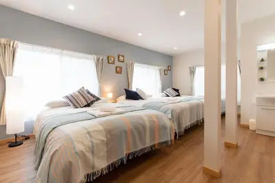 two beds in a bedroom with two windows at TK Court Ojima - Vacation STAY 91237 in Tokyo