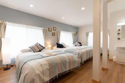 two beds in a bedroom with two windows at TK Court Ojima - Vacation STAY 91237 in Tokyo