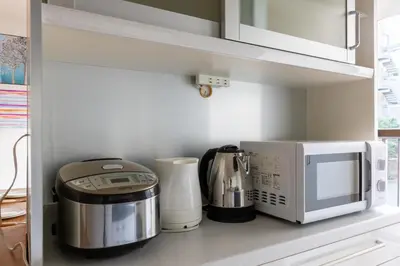 a kitchen with a coffee maker and a microwave at ColorBee Shinjuku Yotsuya Big House in Tokyo