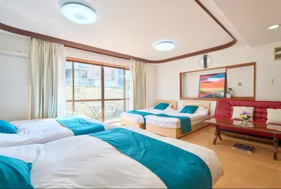 a hotel room with three beds and a couch at ColorBee Shinjuku Yotsuya Big House in Tokyo