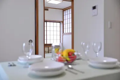 a table with white plates and glasses on it at Green House 101 in Tokyo