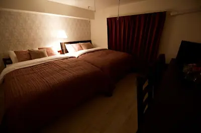 a bedroom with a large bed with a red curtain at Prime Stage Otsuka 204 - Vacation STAY 8875 in Tokyo
