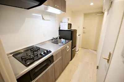 a kitchen with a stove and a sink and a refrigerator at Prime Stage Otsuka 204 - Vacation STAY 8875 in Tokyo