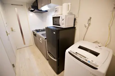 a small kitchen with a microwave on top of a refrigerator at Prime Stage Otsuka 204 - Vacation STAY 8875 in Tokyo