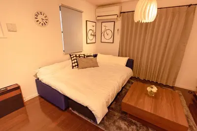 a bedroom with a bed with a table and a clock at Katsushika-ku - House - Vacation STAY 89073 in Tokyo