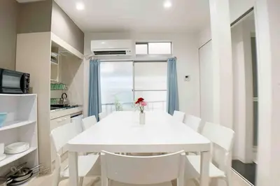 a white dining room with a white table and white chairs at Sunstay - Shinbamba 1 in Tokyo