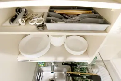 a kitchen drawer with plates and utensils on it at Sunstay - Shinbamba 1 in Tokyo