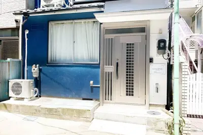 a blue house with a white door and a door at Sunstay - Shinbamba 1 in Tokyo