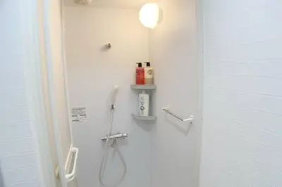 a bathroom with a shower with a sink and a toilet at Sunstay - Shinbamba 1 in Tokyo