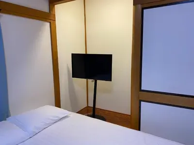 a bedroom with a bed and a flat screen tv at Sun Stay \u5927\u5d0e1 in Tokyo