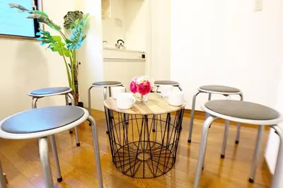 a table with four chairs and a table with flowers on it at Sun Stay \u5927\u5d0e1 in Tokyo