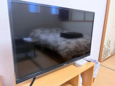 a large flat screen tv sitting on a table with a bed at Hotel EL Shinjuku 6 in Tokyo