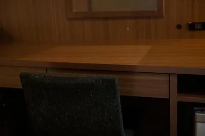 a black chair sitting in front of a wooden desk at KOKO HOTEL Ginza-1chome in Tokyo