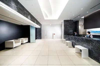a lobby of a building with a person standing at a counter at KOKO HOTEL Ginza-1chome in Tokyo